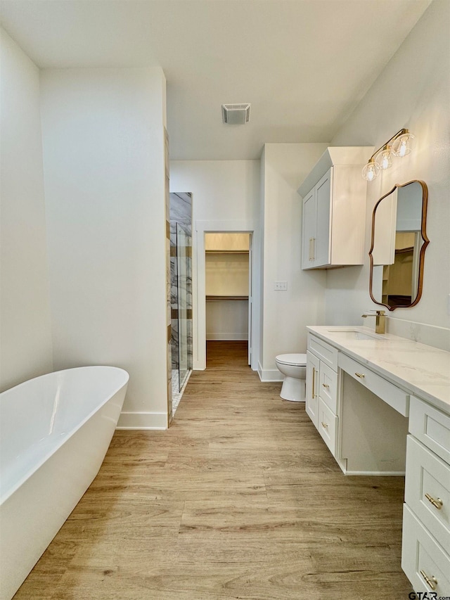 full bathroom featuring wood-type flooring, vanity, toilet, and separate shower and tub