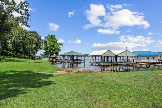 view of dock with a lawn and a water view