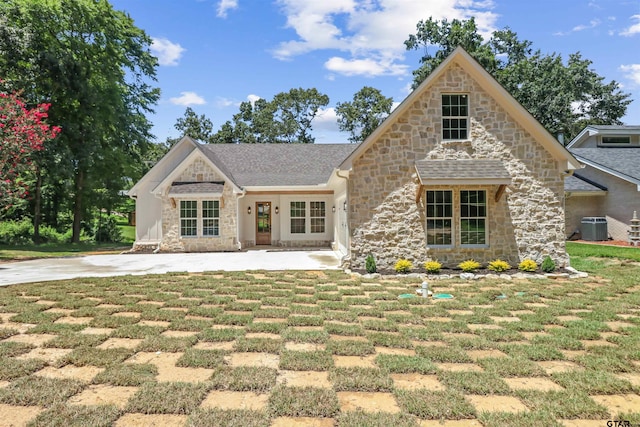 view of front of property featuring cooling unit and a front lawn