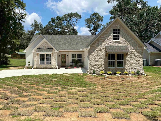 view of front of home featuring central AC and a front lawn