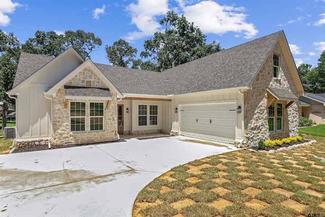 view of front of property featuring a front yard, a garage, and central AC unit