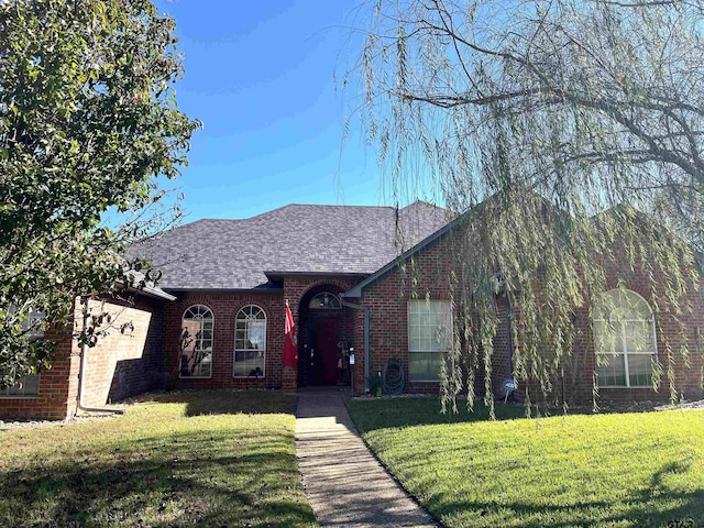 9112 Deerfield Dr, Tyler, TX 75703 - view of front of house featuring a front lawn, brick siding, and roof with shingles