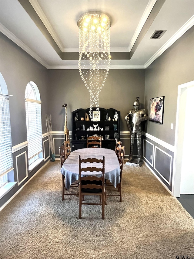 9112 Deerfield Dr, Tyler, TX 75703 - carpeted dining area featuring a tray ceiling, a chandelier, ornamental molding, a decorative wall, and a wainscoted wall