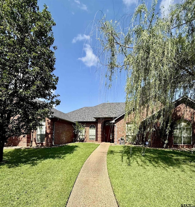 9112 Deerfield Dr, Tyler, TX 75703 - ranch-style home with brick siding, a front yard, and roof with shingles