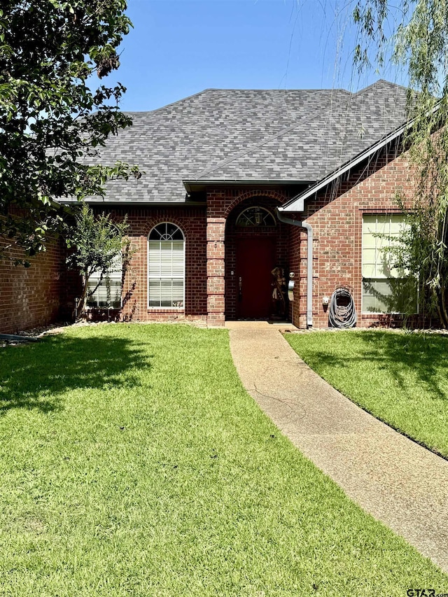 9112 Deerfield Dr, Tyler, TX 75703 - view of front of house with a shingled roof, brick siding, and a front lawn