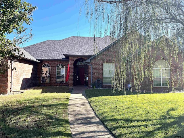 9112 Deerfield Dr, Tyler, TX 75703 - view of front of property featuring brick siding, a front yard, and roof with shingles