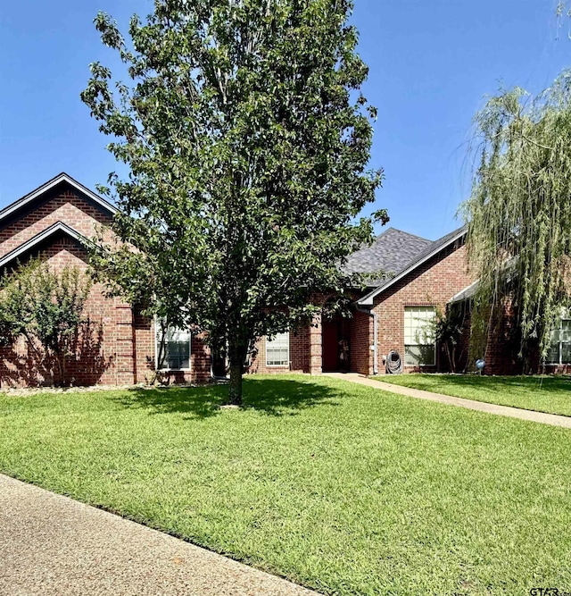 9112 Deerfield Dr, Tyler, TX 75703 - view of front of house with brick siding, a front lawn, and a shingled roof