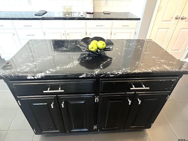 9112 Deerfield Dr, Tyler, TX 75703 - kitchen featuring dark cabinets, a center island, white cabinets, tile patterned floors, and tasteful backsplash