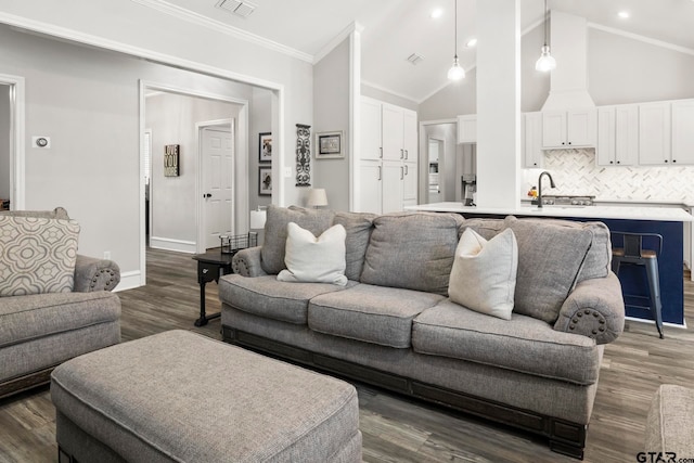 living room featuring high vaulted ceiling, dark hardwood / wood-style floors, crown molding, and sink