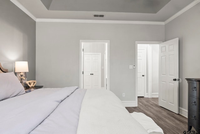 bedroom with dark hardwood / wood-style floors and crown molding