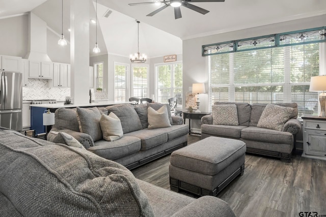 living room featuring ceiling fan with notable chandelier, dark wood-type flooring, crown molding, and high vaulted ceiling