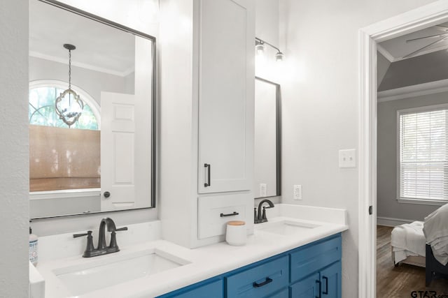 bathroom with vanity, hardwood / wood-style floors, a notable chandelier, and ornamental molding