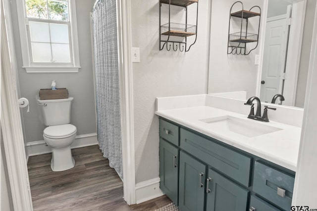 bathroom with hardwood / wood-style flooring, vanity, and toilet