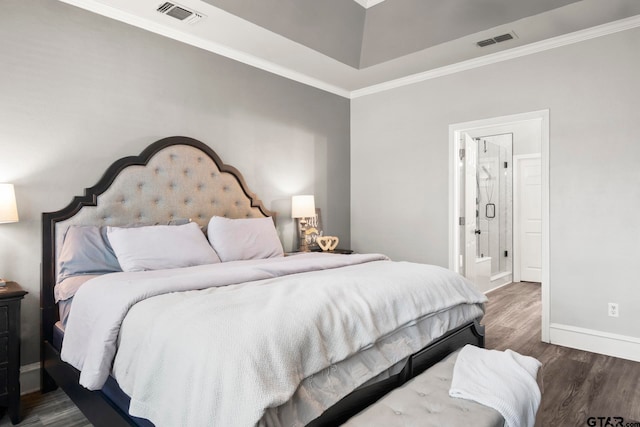 bedroom with hardwood / wood-style flooring, ensuite bath, and crown molding