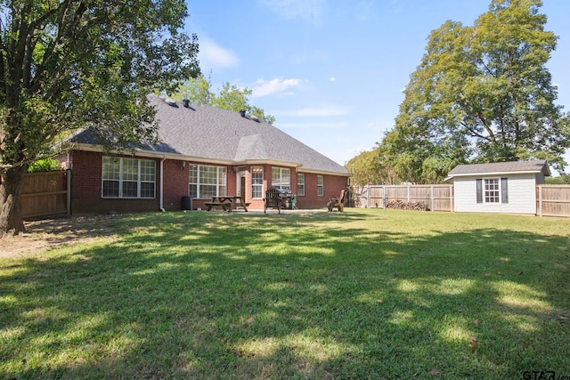 rear view of house featuring a storage unit, a yard, and a patio area