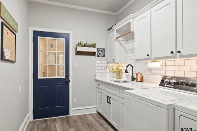 laundry area with crown molding, dark hardwood / wood-style floors, cabinets, sink, and washing machine and dryer