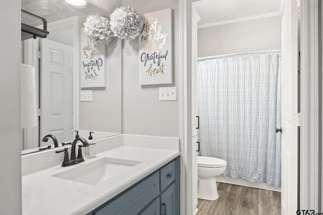 full bathroom with hardwood / wood-style flooring, ornamental molding, shower / bathtub combination with curtain, vanity, and toilet