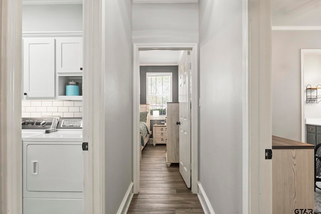 hallway featuring independent washer and dryer, dark hardwood / wood-style floors, and crown molding