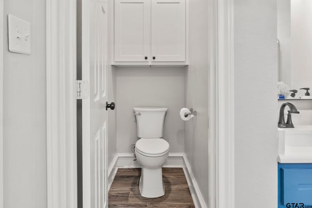 bathroom with hardwood / wood-style flooring, vanity, and toilet