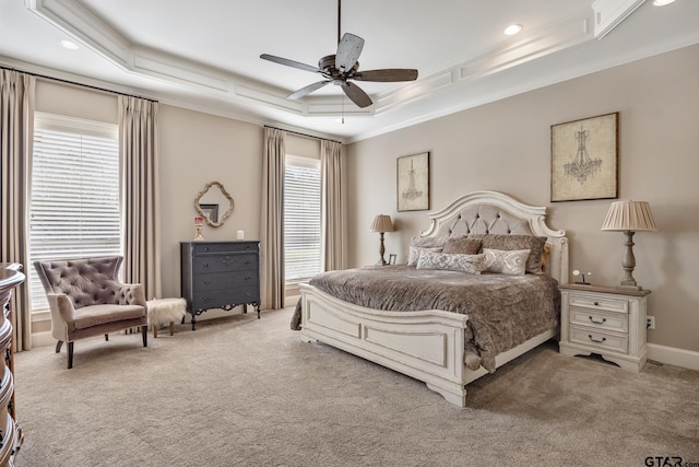 bedroom featuring ceiling fan, crown molding, light carpet, and a tray ceiling