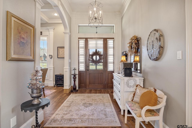 foyer featuring plenty of natural light, ornamental molding, and dark wood-type flooring