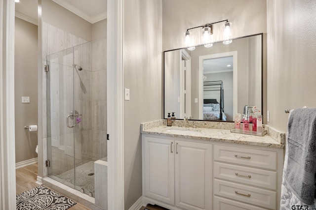 bathroom with vanity, hardwood / wood-style flooring, walk in shower, and crown molding