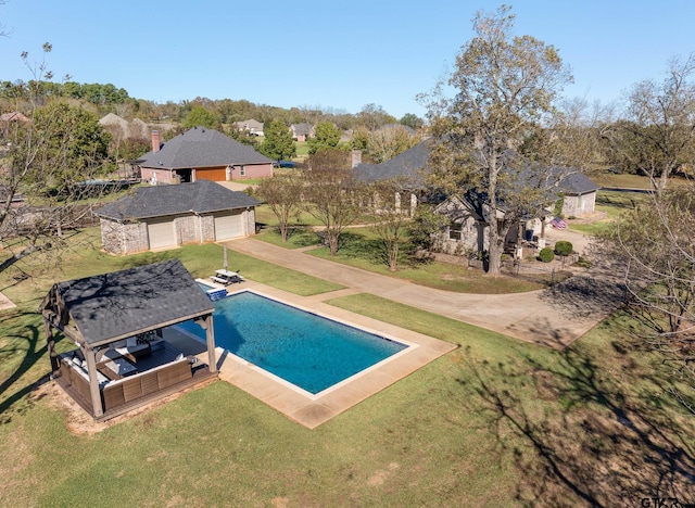 view of pool featuring a lawn, an outdoor structure, and a garage