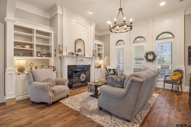 living room with a tile fireplace, dark hardwood / wood-style flooring, decorative columns, and ornamental molding