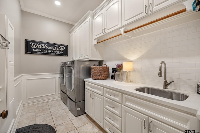 washroom with sink, cabinets, independent washer and dryer, light tile patterned floors, and ornamental molding