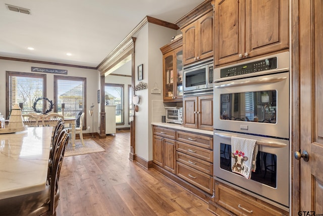 kitchen featuring crown molding, stainless steel appliances, and wood-type flooring