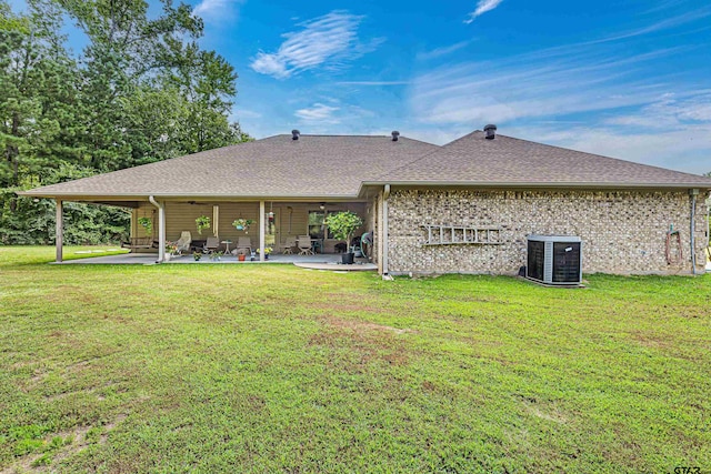 back of property with central air condition unit, a yard, and a patio area