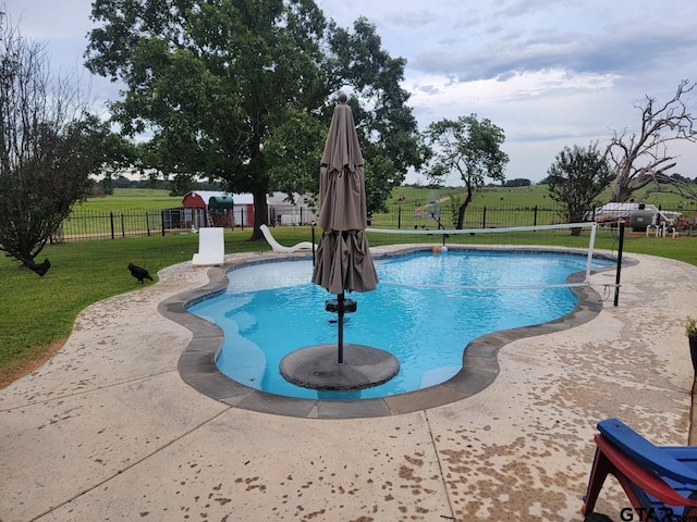 view of swimming pool with a yard