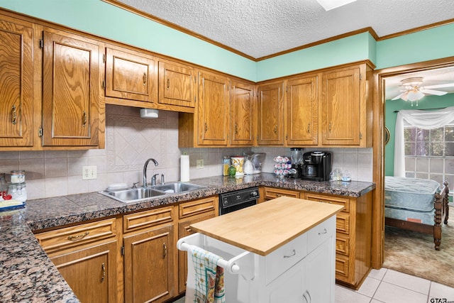 kitchen featuring a textured ceiling, sink, light tile patterned floors, ceiling fan, and crown molding