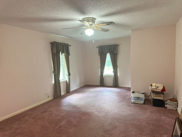 empty room featuring a textured ceiling, carpet floors, and ceiling fan