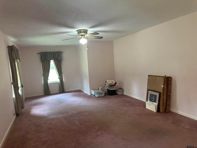 carpeted spare room featuring a textured ceiling and ceiling fan