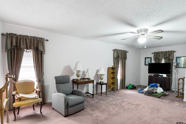 sitting room with carpet flooring, a textured ceiling, and ceiling fan