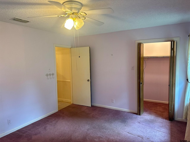 empty room with ceiling fan, a textured ceiling, and carpet flooring