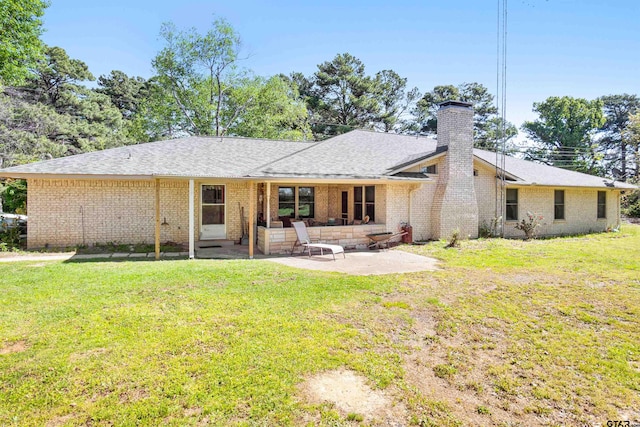 rear view of house with a patio and a yard