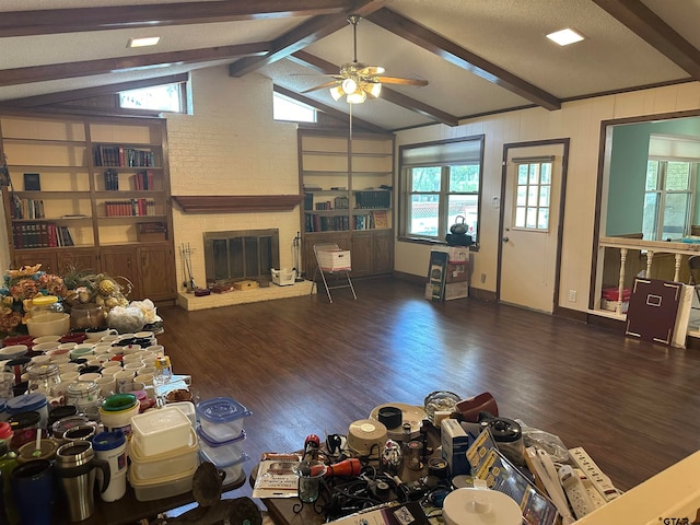 living room featuring dark wood-type flooring, ceiling fan, vaulted ceiling with beams, and a fireplace