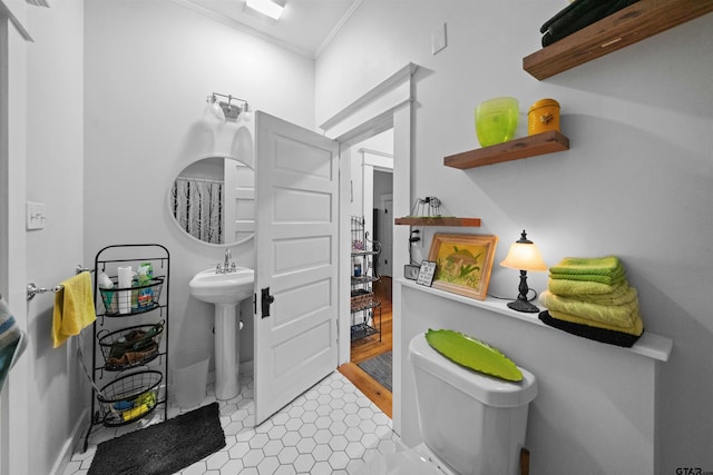 bathroom featuring toilet, ornamental molding, and tile patterned flooring