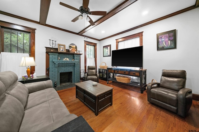 living room featuring ceiling fan, beam ceiling, a fireplace, and wood-type flooring