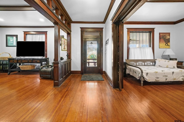 foyer featuring hardwood / wood-style floors, crown molding, and a healthy amount of sunlight