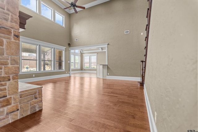 2312 Pinehurst Dr, Tyler, TX 75703 - unfurnished living room with wood finished floors, a ceiling fan, baseboards, and a towering ceiling