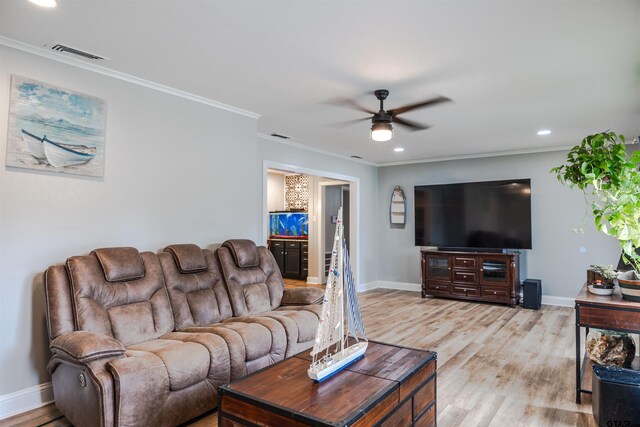 living room with light wood-type flooring, ceiling fan, and crown molding