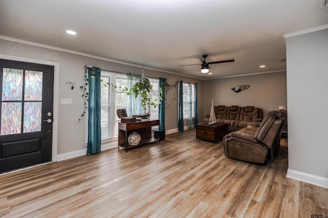 living room featuring ornamental molding, light wood-type flooring, and ceiling fan