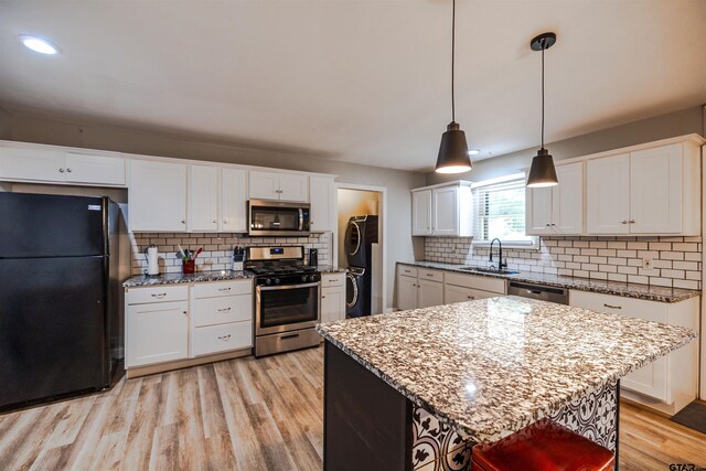 kitchen featuring pendant lighting, white cabinets, sink, and stainless steel appliances