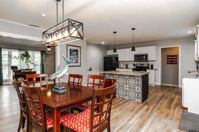 dining area with light wood-type flooring and sink