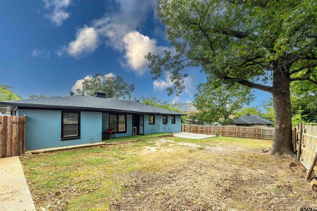 back of house featuring a lawn and a patio