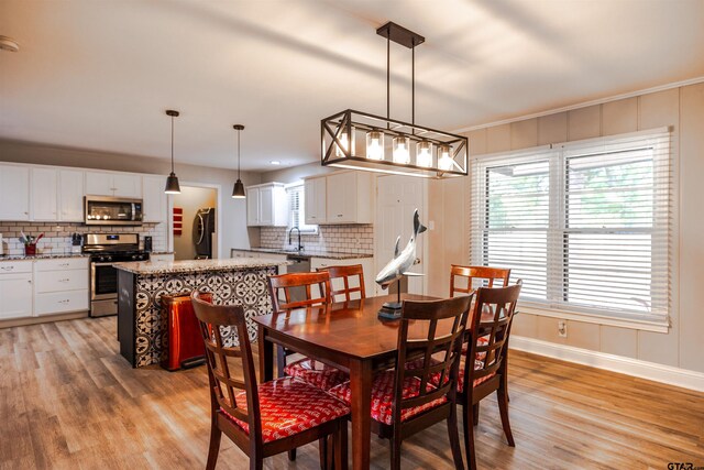 dining area featuring light hardwood / wood-style floors, a healthy amount of sunlight, and sink