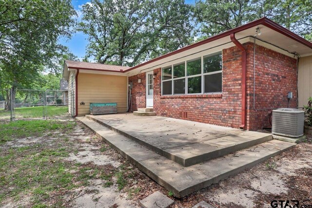 415 Lonestar Ln, Hideaway, TX 75771 - view of home's exterior with brick siding, fence, a patio, cooling unit, and a gate